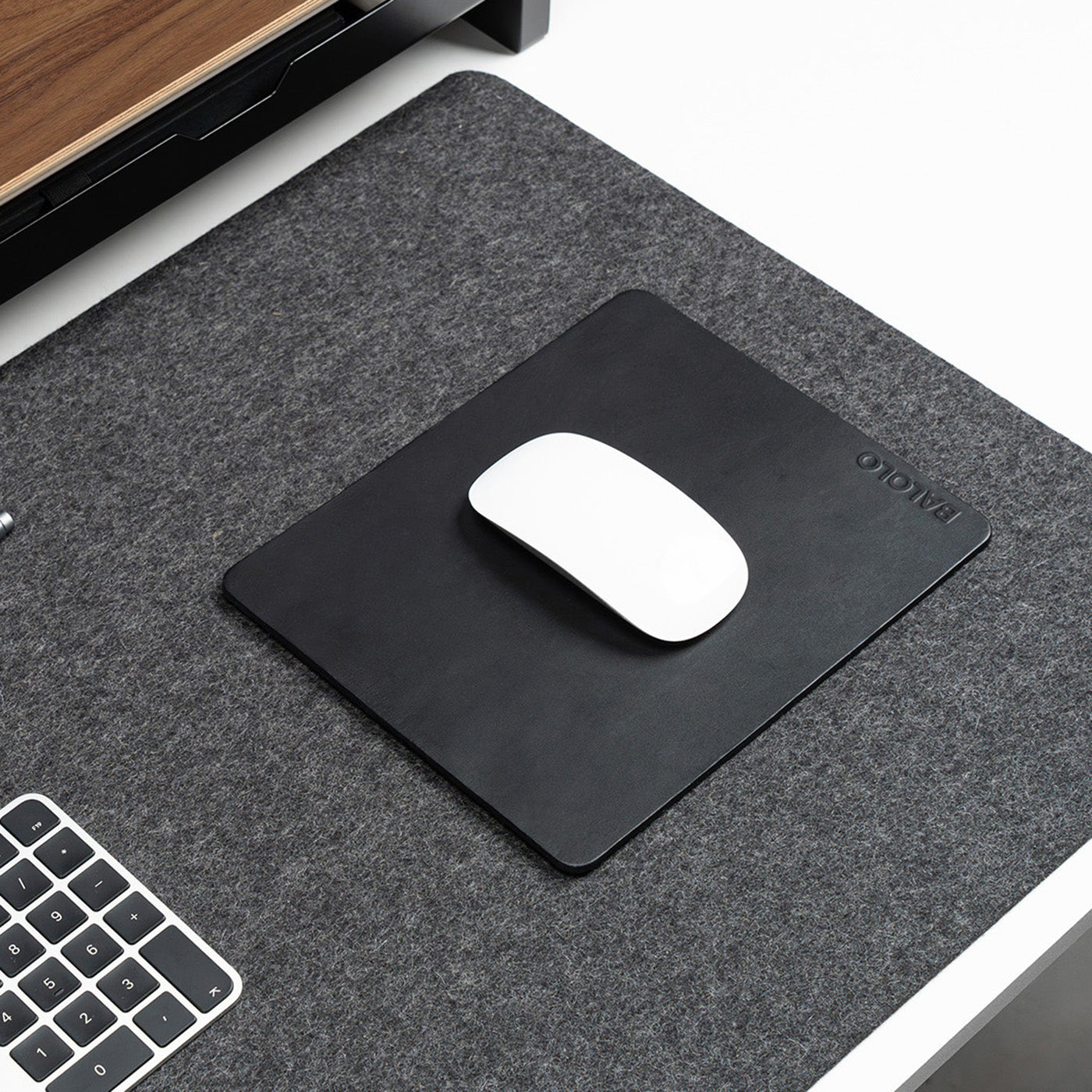 Mauspad Leder in der Detailansicht auf einem Desk Pad Large, mit weißer Apple Magic Maus dargestellt.