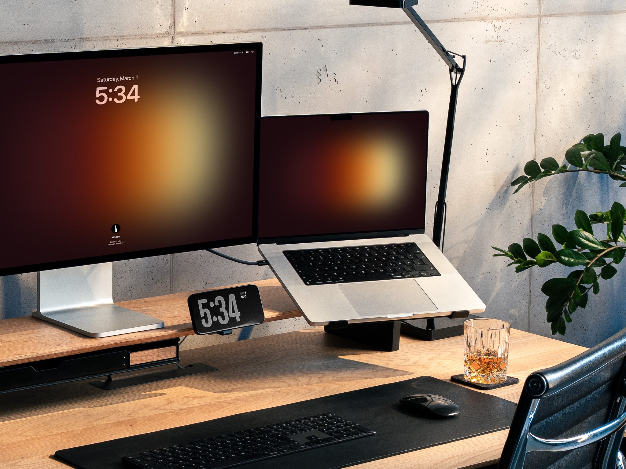 BALOLO Laptophalter montiert am Setup Cockpit Monitorständer mit einem Macbook in der Halterung. Setup ergänzt durch Apple Studio Display und iPhone in modernem Office Setting. @expand