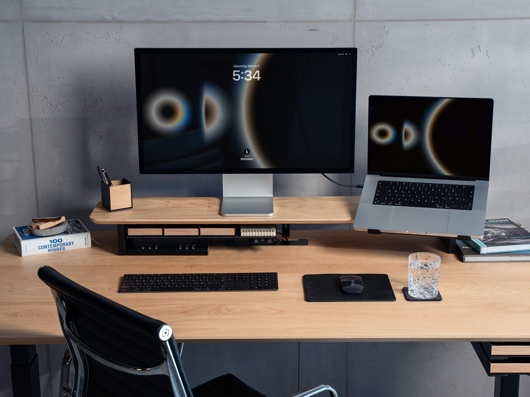 BALOLO Laptophalter montiert am Setup Cockpit Monitorständer mit einem Macbook in der Halterung. Setup ergänzt durch Apple Studio Display in modernem Office Setting. @expand