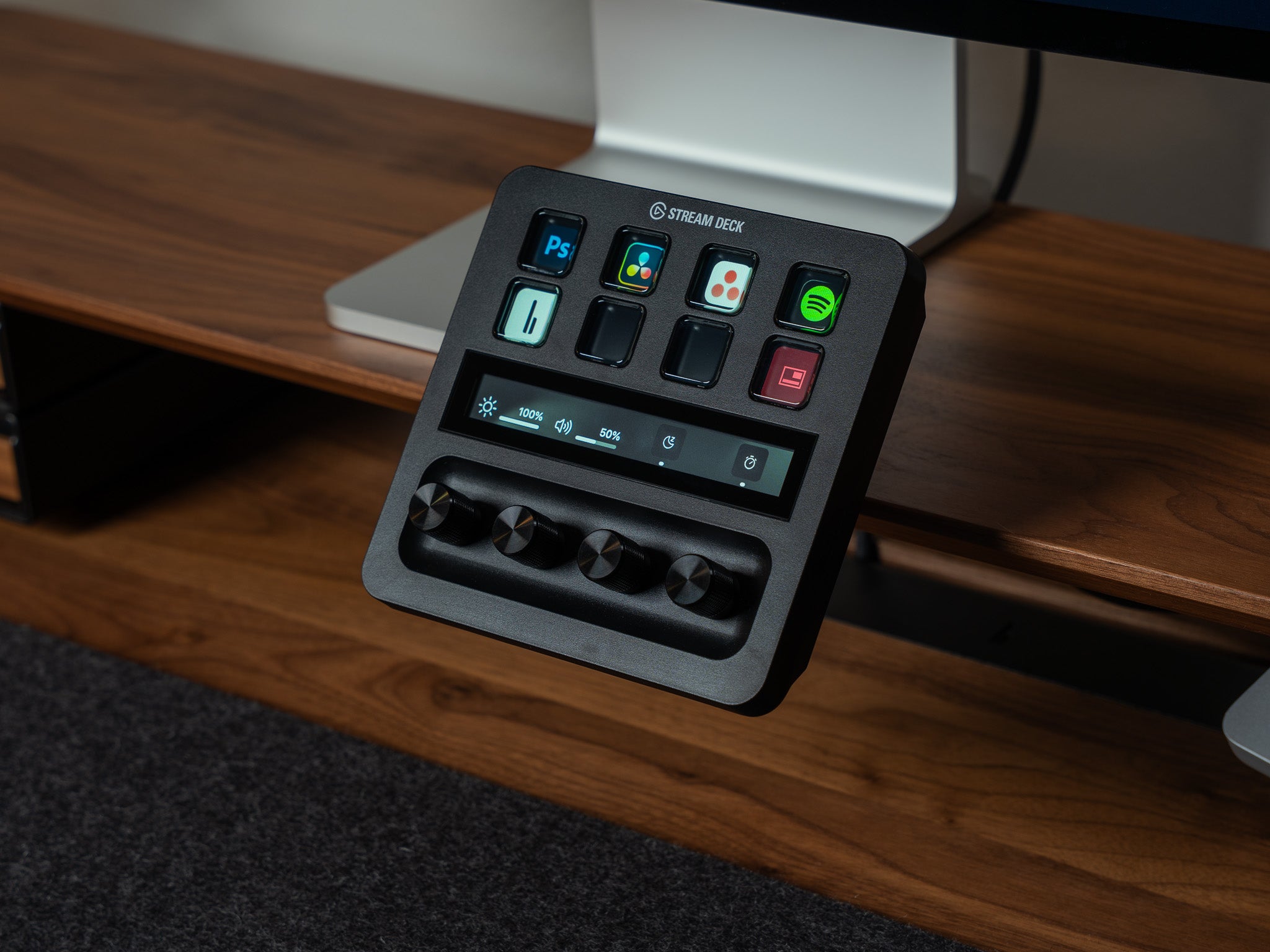Detailaufnahme von BALOLO Stream Deck Plus Halter mit elgato Stream Deck Plus in der Halterung montiert am Setup Cockpit Monitorständer Nussbaum. In Szene gesetzt in ästhetischem Office Setup. @expand