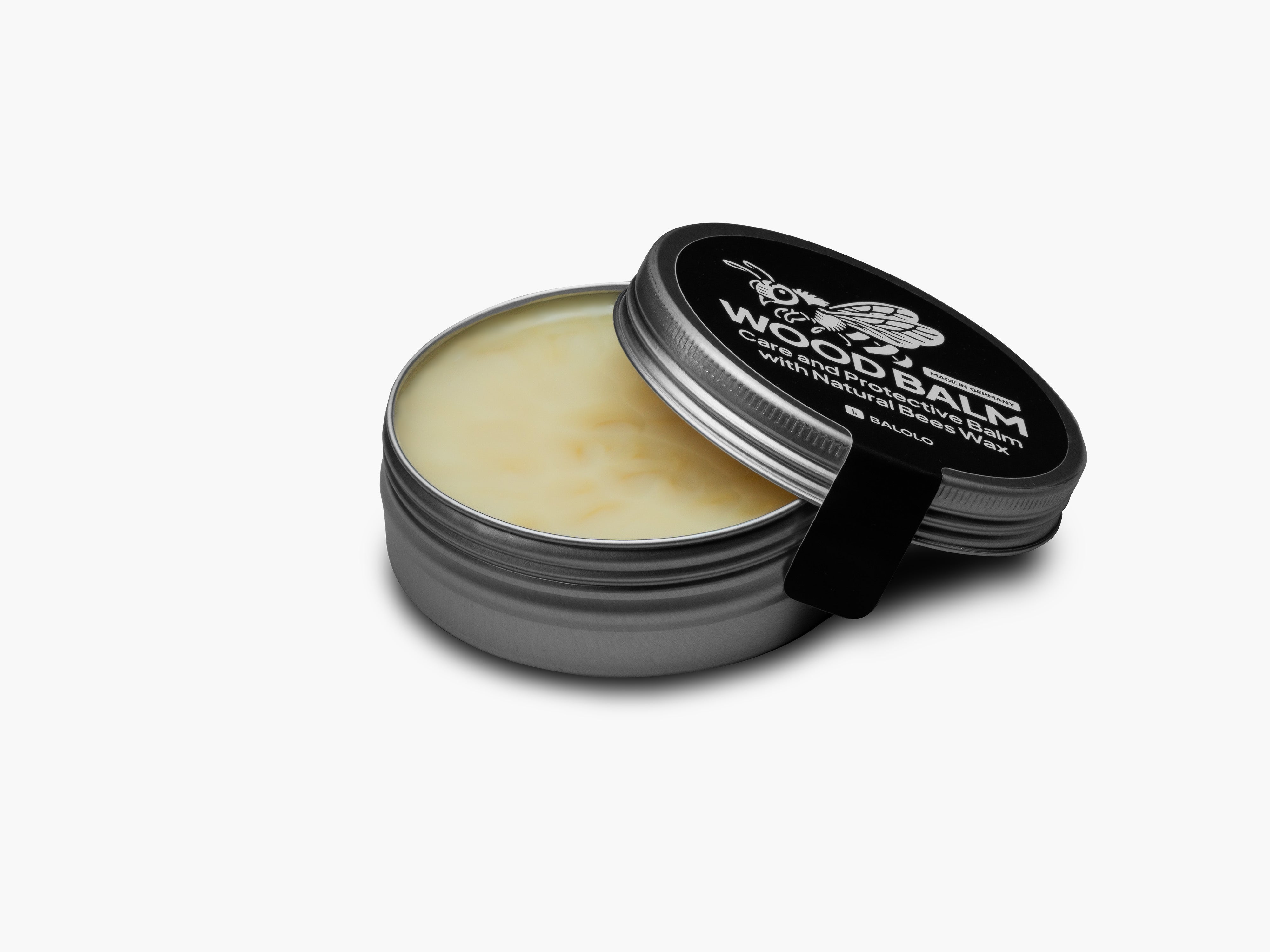 Produktfoto des Wood Balms freigestellt auf grauem Hintergrund. Deck ist geöffnet und leicht auf die Dose angelehnt.