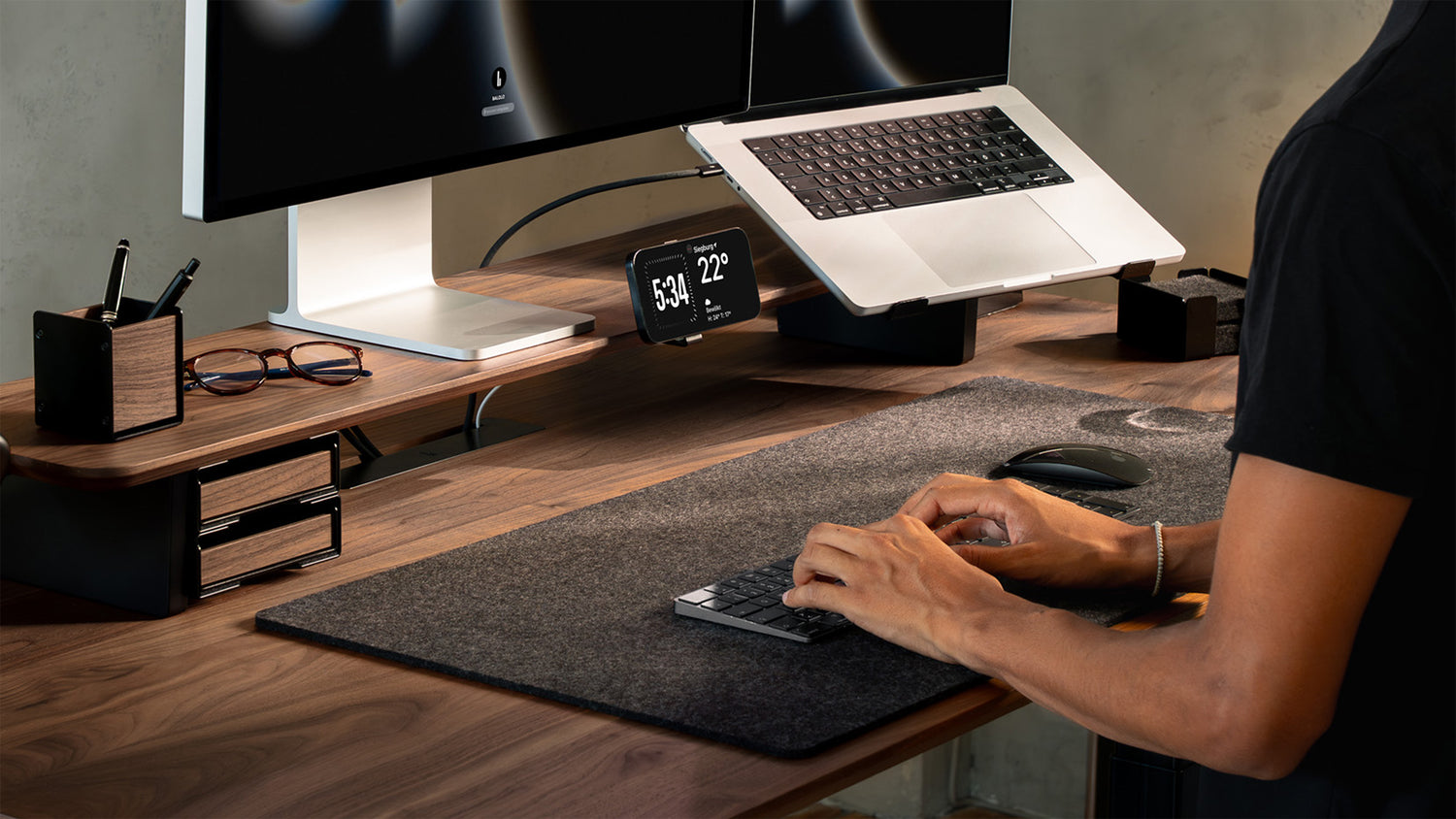 Laptop auf Laptophalter an einem Setup Cockpit aus Nussbaum mit Apple Studio Display und Desk Mat Large