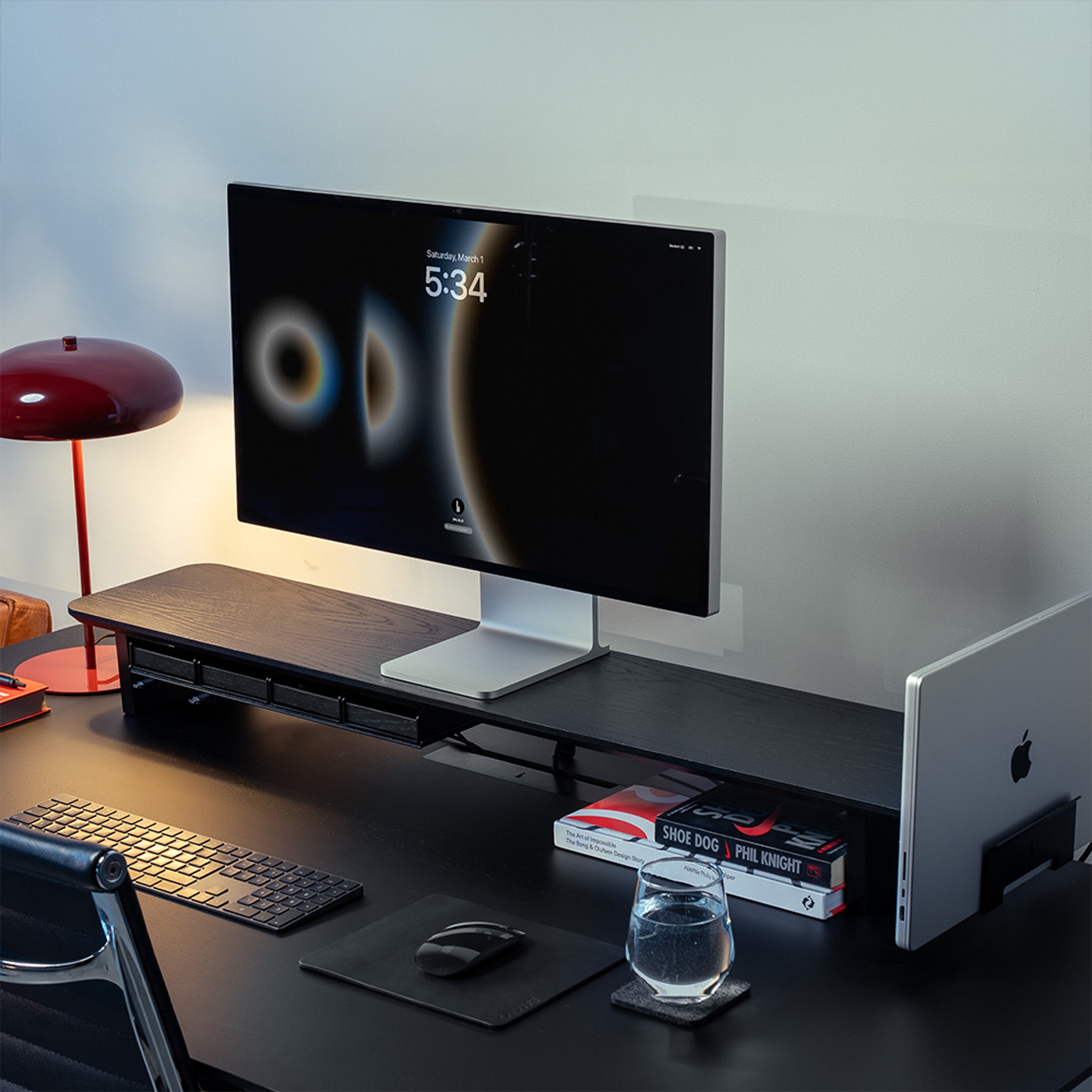 Setup Cockpit Monitorständer in schwarz gefärbter Eiche auf einem schwarzen Schreibtisch mit integriertem Laptophalter und Fach im modernen Office Setting.