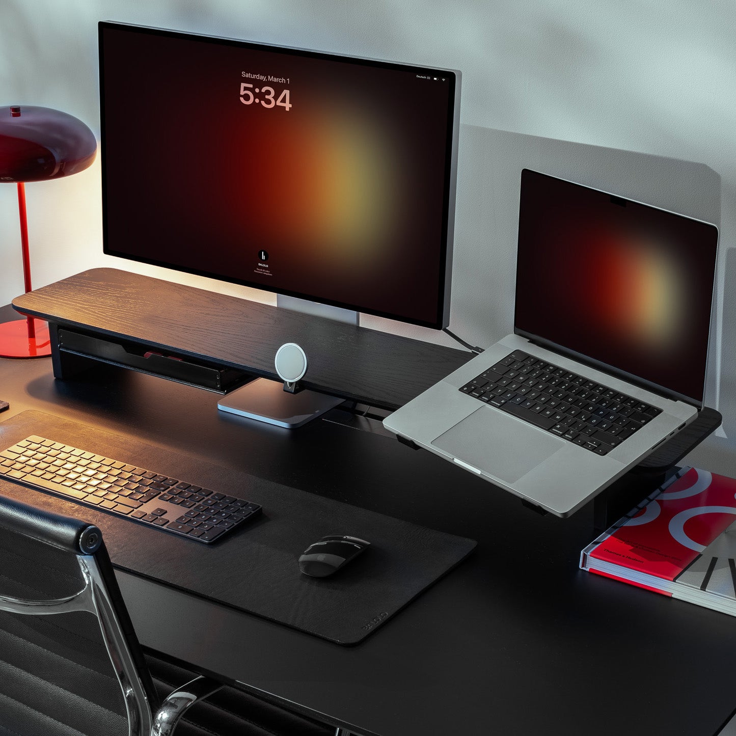 Setup Cockpit Large aus schwarz gefärbter Eiche mit Laptophalter und MagSafe Halter auf einem schwarzen Schreibtisch im modernen Office Setting.