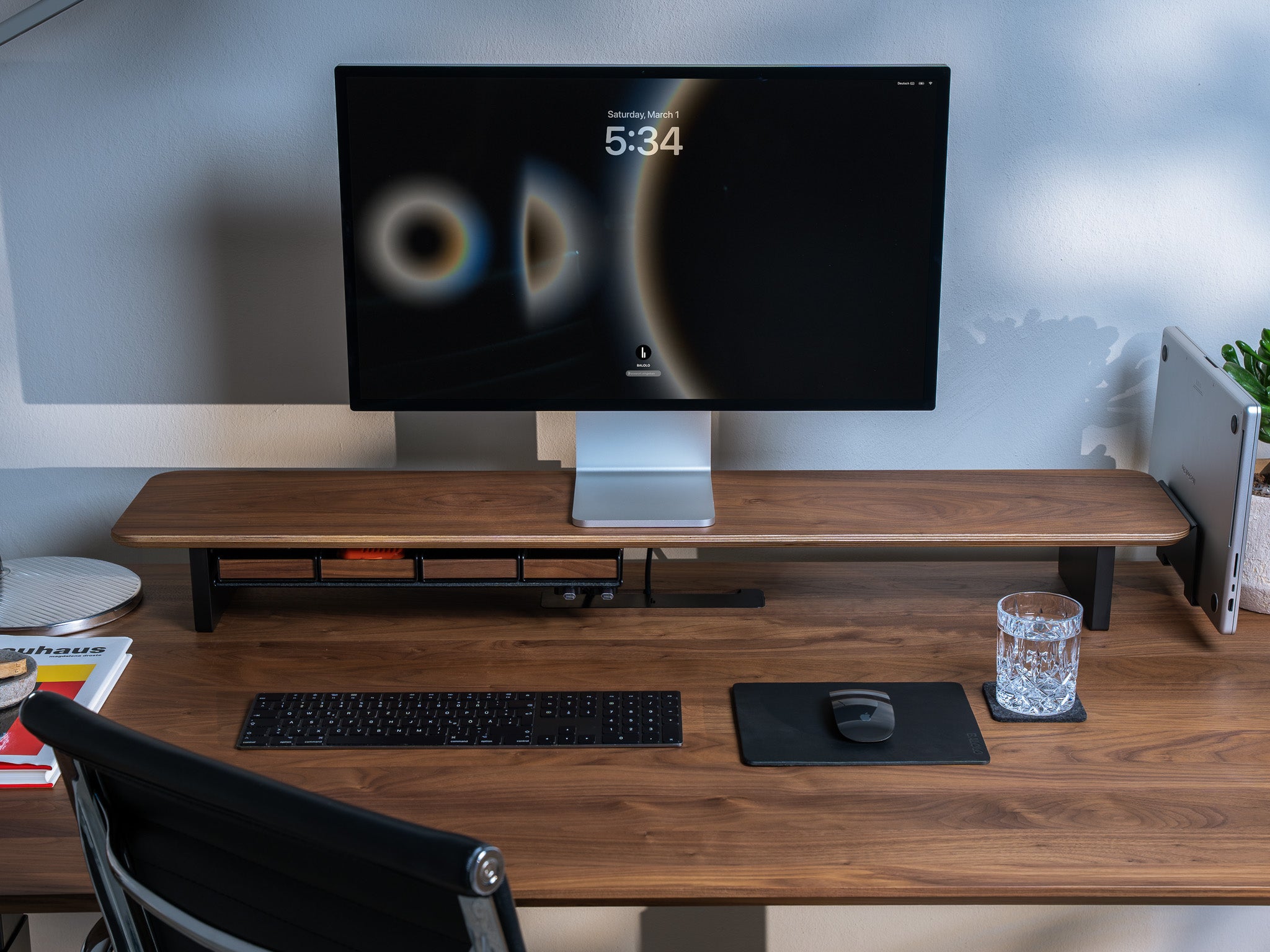 Setup Cockpit Monitorständer aus Nussbaum auf Schreibtisch aus Nussbaum mit einem Monitor und Laptop in Laptop Dock. Modernes Home Office Setting.