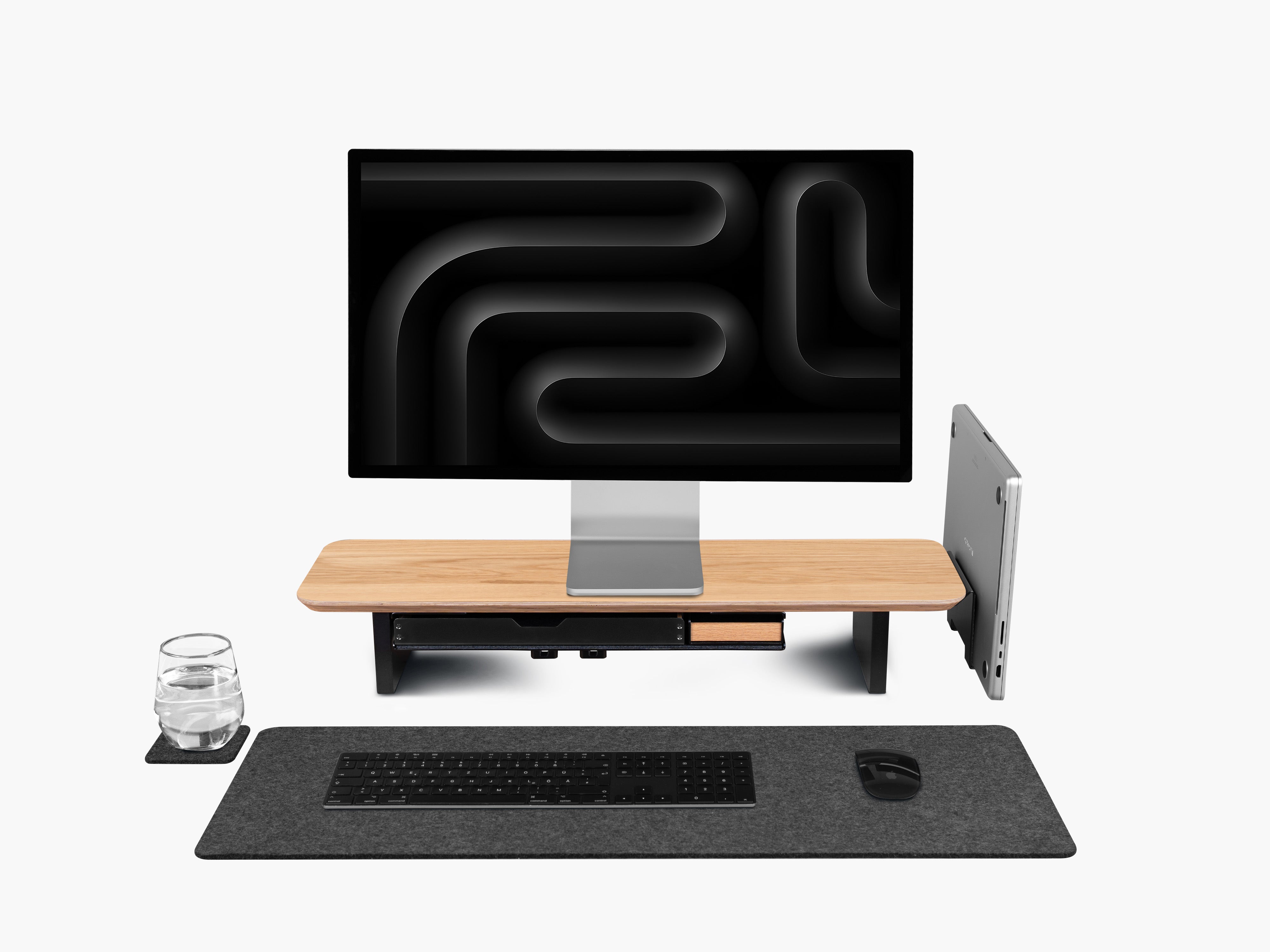Setup Cockpit Monitorständer Medium aus Eiche mit Anbauteilen: Laptop Dock, großes Fach mit Stiftablage Large und Stiftablage, Kabelmagneten, Desk Pad Large und Desk Coaster. Abgebildet mit Apple Studio Display, Macbook, Tastatur und Maus.