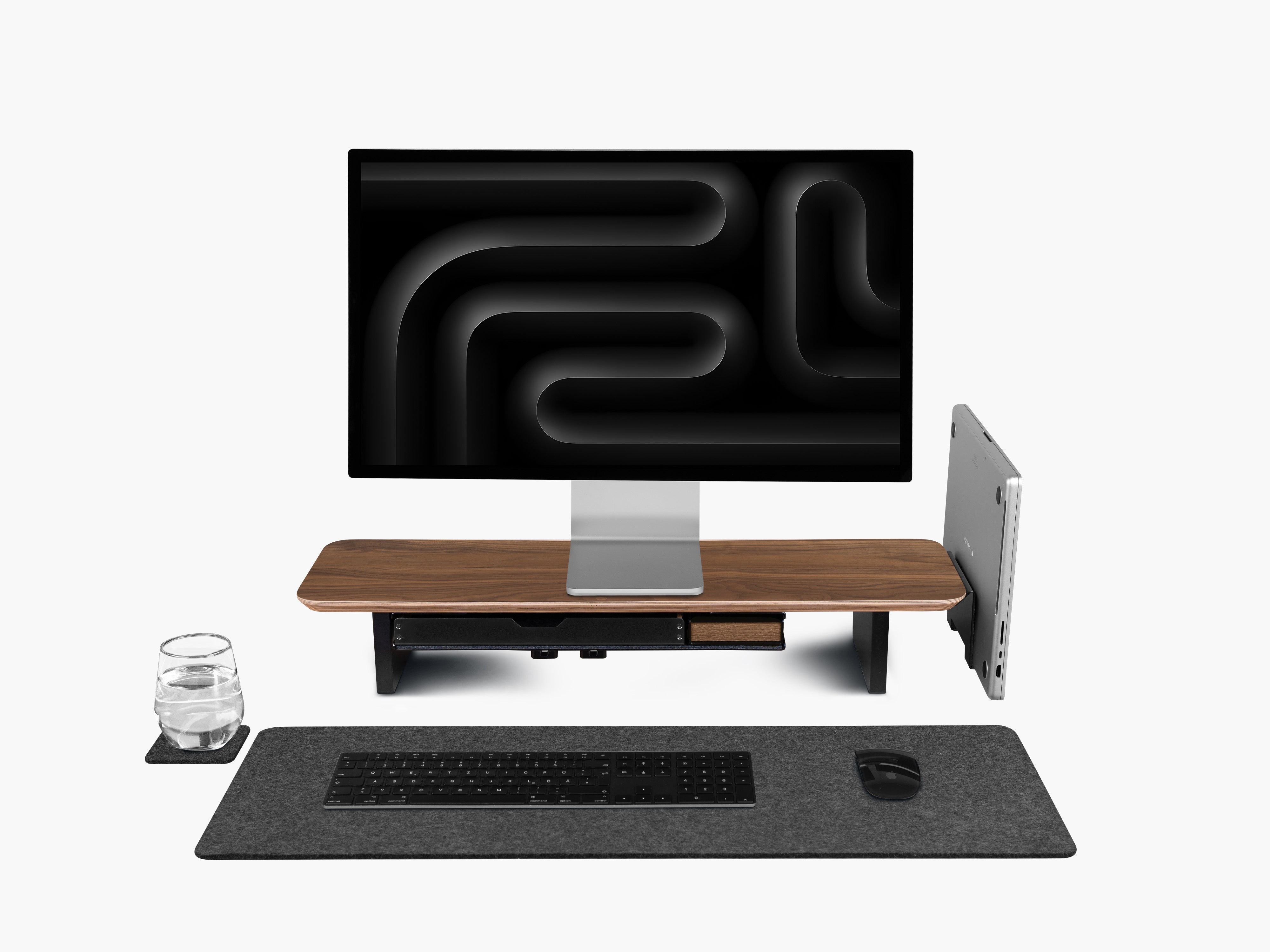 Setup Cockpit Monitorständer Medium aus Nussbaum mit Anbauteilen: Laptop Dock, großes Fach mit Stiftablage und Stiftablage Large, Kabelmagneten, Desk Pad und Desk Coaster. Abgebildet mit Apple Studio Display, Tastatur und Maus.