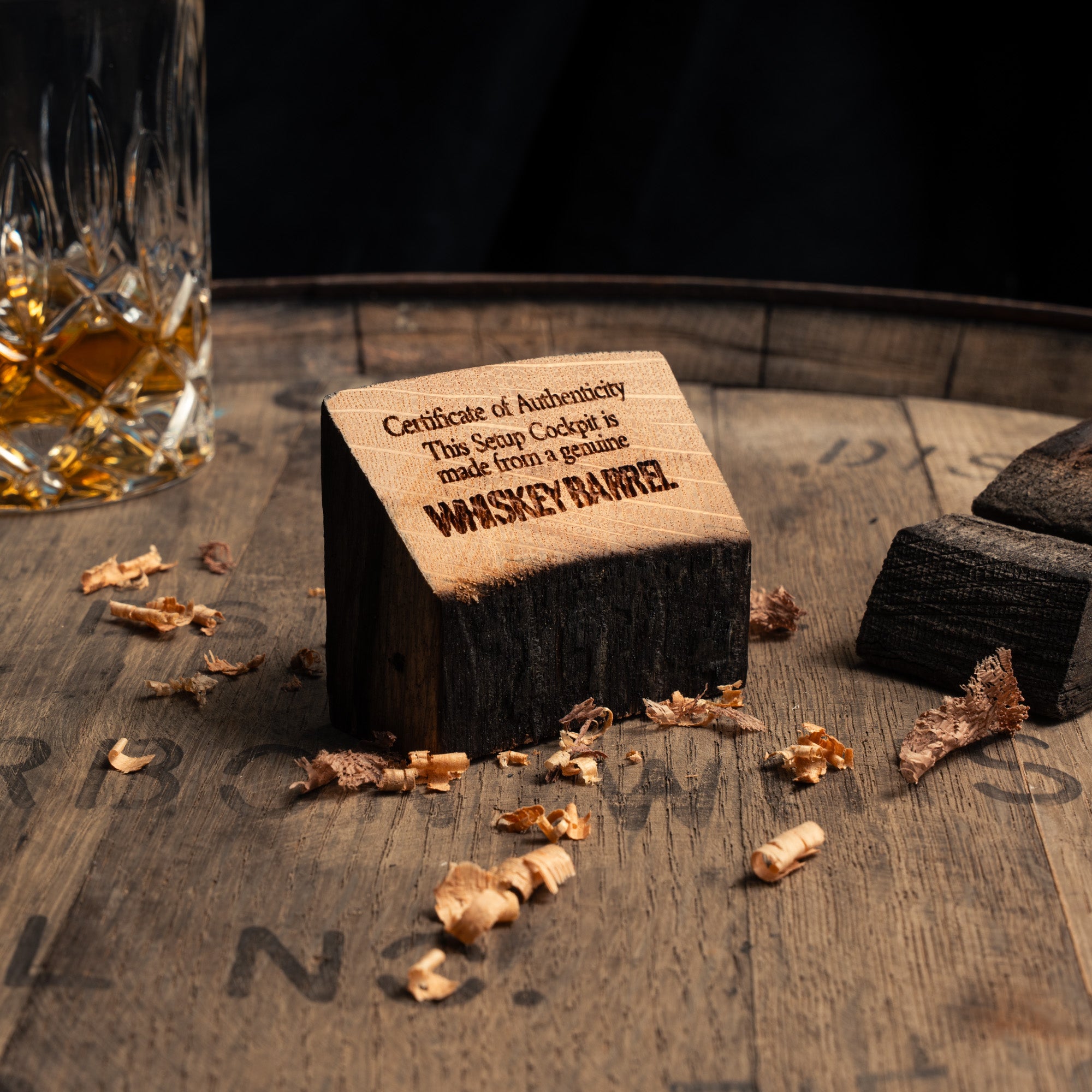 Certificate of Authenticity der Whiskey Barrel Edition, inszeniert auf einem Whiskeyfass mit Holzspähnen und Fassdaube.