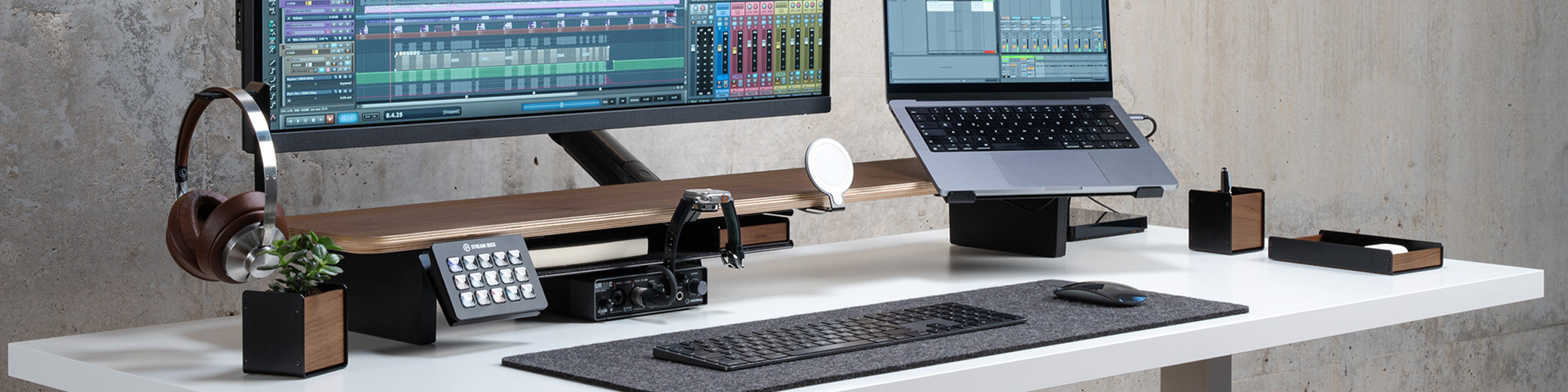 Setup Cockpit Monitorständer auf weißem Schreibtisch mit Laptophalter, Kopfhörerhalter, MagSafe Halterung und Smartwatch Halterung ausgestattet. Inszeniert in modernem Office Setting.