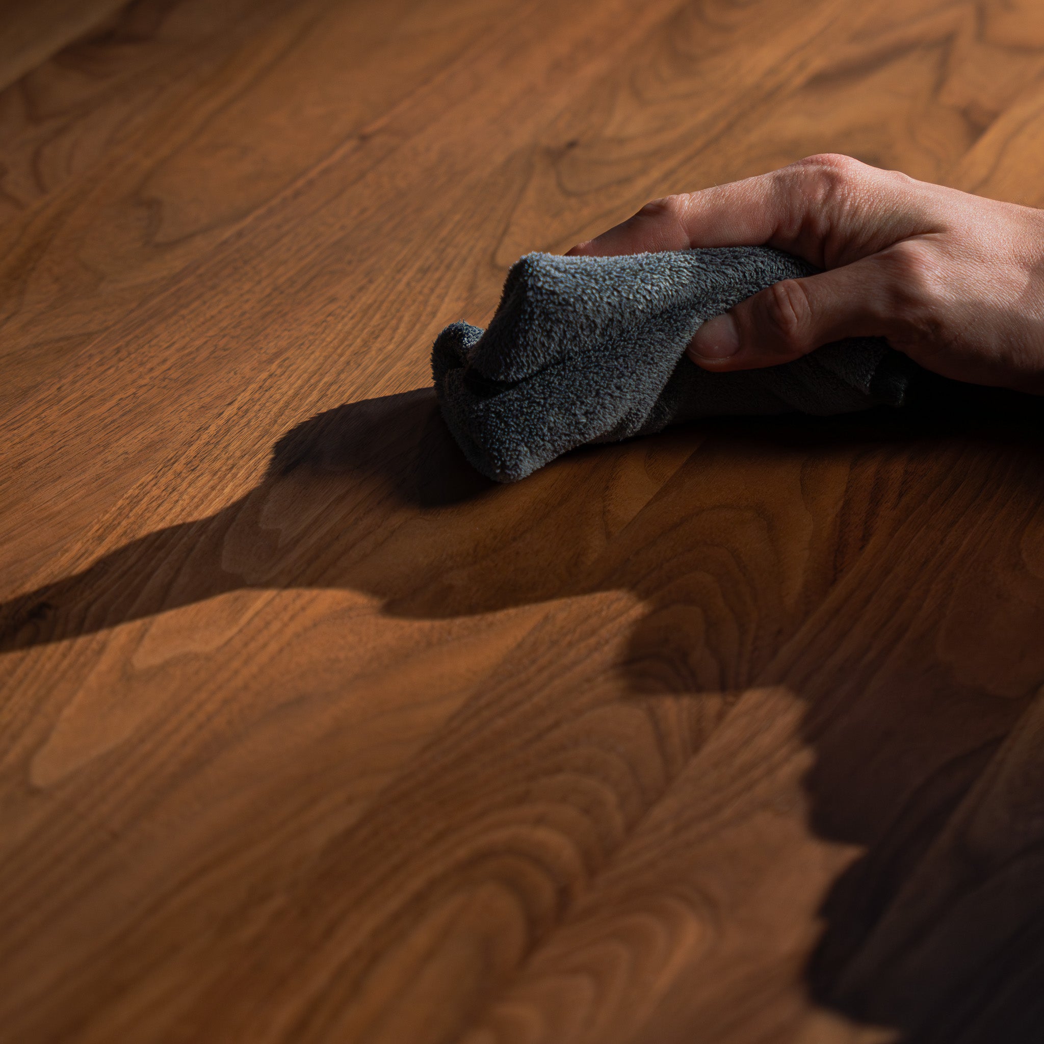 BALOLO Holzpflege wird auf Nussbaum Tisch aufgetragen mit weichem Mikrofasertuch.