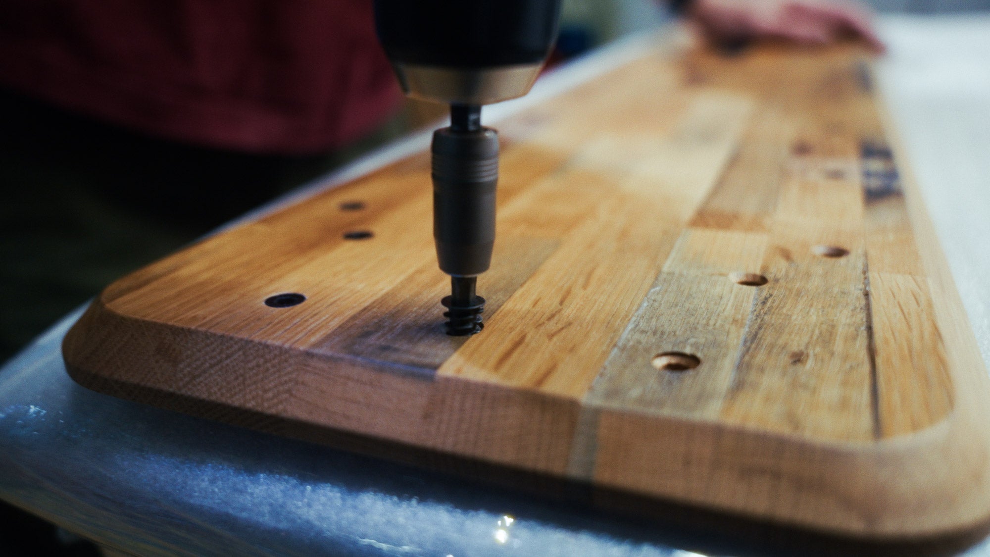 Nahaufnahme eines Setup Cockpits der Whiskey Barrel Edition. Muffen werden von einem Handwerker in das Montageraster gedreht.